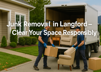 Junk removal crew loading a truck outside a Langford home, with green hills and a clean yard in the background.